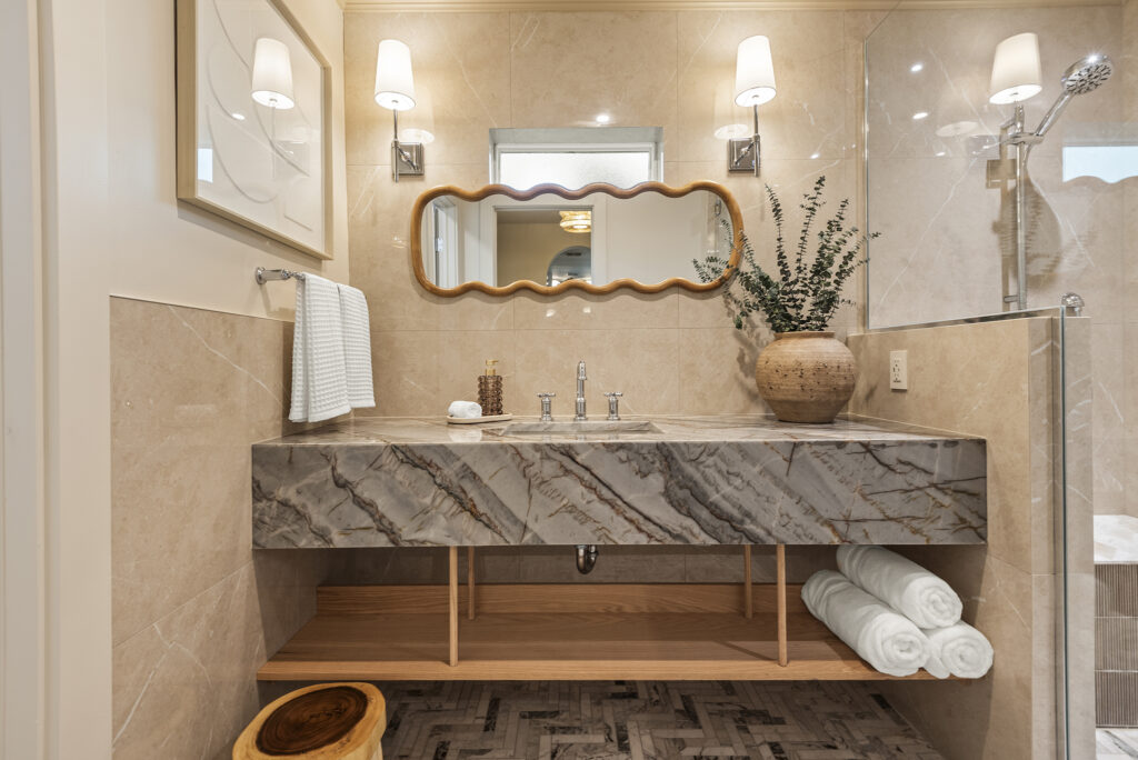 Elegant spa inspired bathroom with a marble vanity, warm lighting, and natural accents inside a boutique Cocoa Beach vacation home.