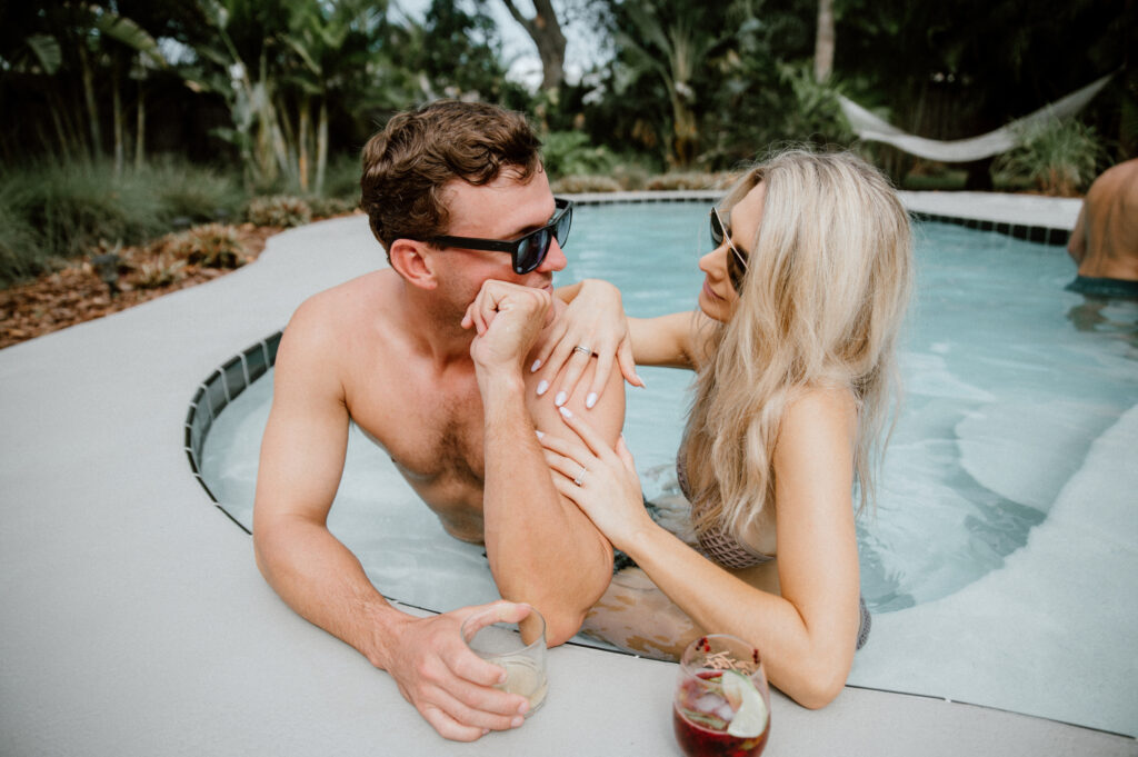Couple relaxing together in a private spa pool surrounded by tropical greenery at a boutique Cocoa Beach vacation home.