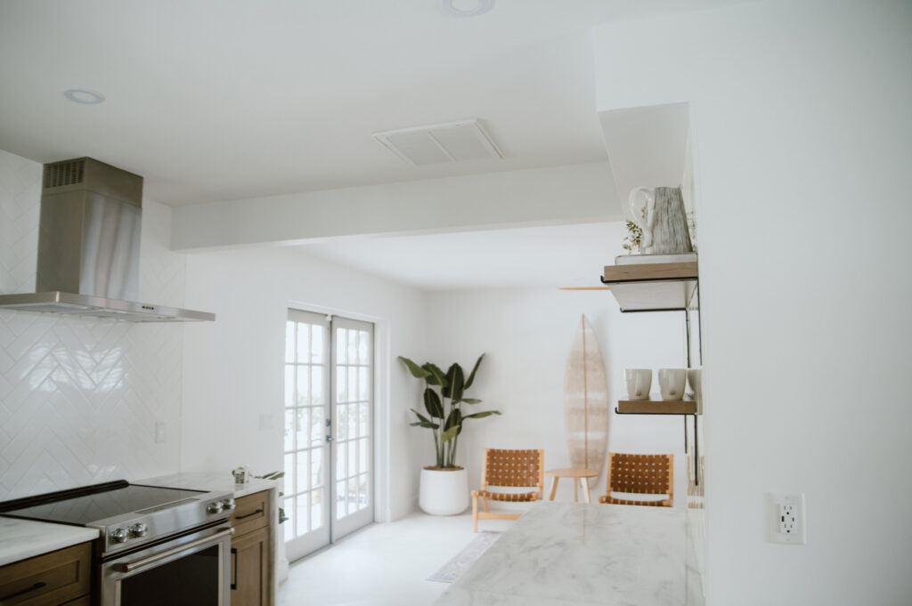 Bright modern kitchen and dining space with natural light and coastal decor inside a boutique Cocoa Beach vacation home.