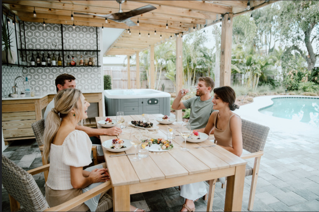 Family enjoying an outdoor dining experience at a luxury vacation home in Cocoa Beach, Florida.