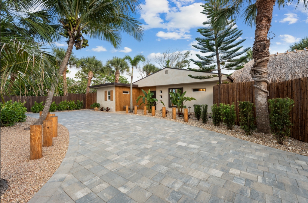 Paved outdoor courtyard with palm trees, patio seating, and a covered outdoor dining area.